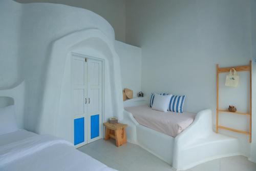 a white bedroom with two beds and a window at iSea by the sea in Ninh Van Bay