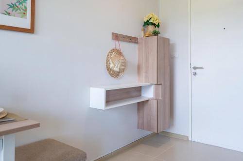 a room with a white wall with a wooden cabinet at ZcapeX2 in Bang Tao Beach