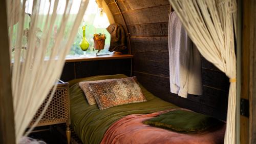 Cama pequeña en habitación con ventana en Tiny Winey House no 2 en Zennewijnen