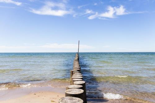 a pier in the ocean on a beach at Gwiazda Morza in Sianozety