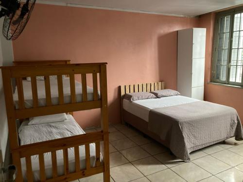 a bedroom with two bunk beds and a ladder at Hostel do Lucca in Porto Alegre