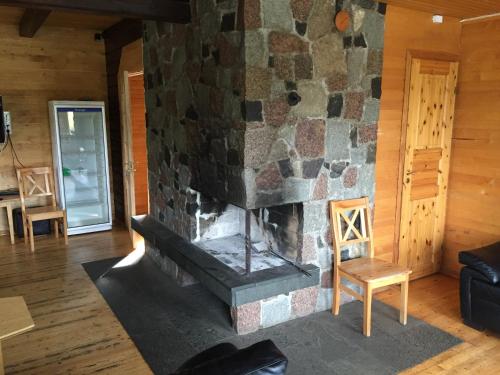 a stone fireplace in a room with a couch and a table at Sammuli Holiday Village in Viljandi
