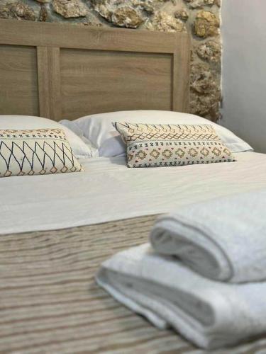 a bed with two pillows and a towel on it at SPITAKI in Kalymnos