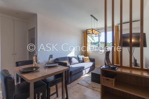 un salon avec un canapé bleu et une table dans l'établissement Appartement Numéro 3, proche plage et commerces, à Cavalaire-sur-Mer