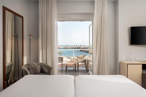 a hotel room with a bed and a view of the ocean at Hotel Baia in Cascais
