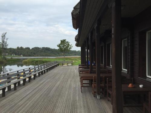 a wooden deck with benches next to a body of water at Sammuli Holiday Village in Viljandi