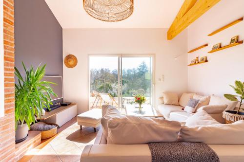 uma sala de estar com um sofá e uma mesa em La Tendresse - Maison Familliale avec Piscine em Mondonville