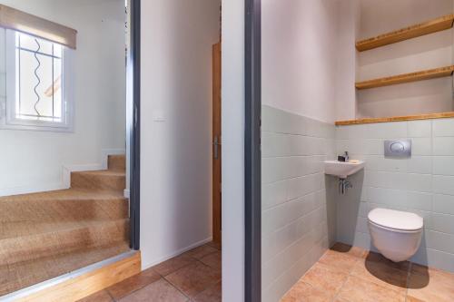 a bathroom with a toilet and a staircase at La Tendresse - Maison Familliale avec Piscine in Mondonville