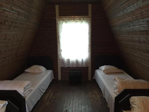 two beds in a room with a window at Sammuli Holiday Village in Viljandi