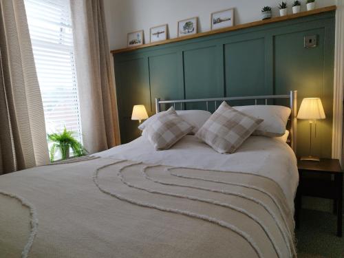 a bedroom with a large bed with two pillows at Mrs Seeleys House in Choppington