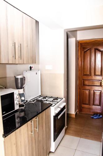 a kitchen with a stove and a refrigerator at Keisha Homes in Thika