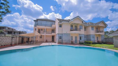 uma casa grande com uma piscina em frente em Longview Suites Hotel em Nairobi