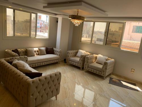 a living room with couches and chairs and windows at شقة جديدة بالكامل in Port Said