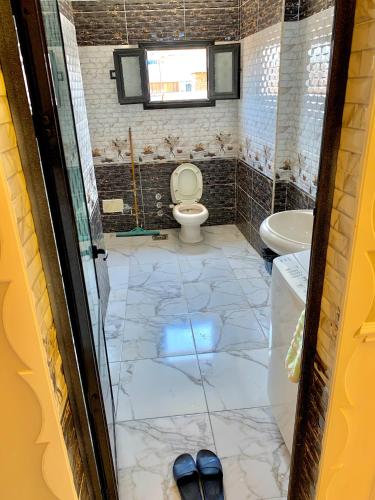 a bathroom with a toilet and a sink at شقة جديدة بالكامل in Port Said