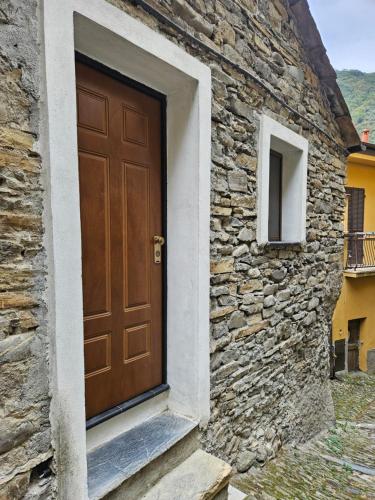 a wooden door on the side of a stone building at Casa Elisa e Casa Giuliana a Badalucco in Badalucco