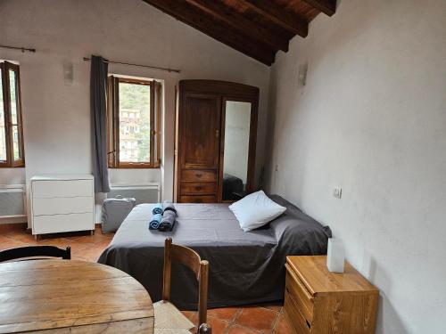 a bedroom with a bed and a wooden table at Casa Elisa e Casa Giuliana a Badalucco in Badalucco