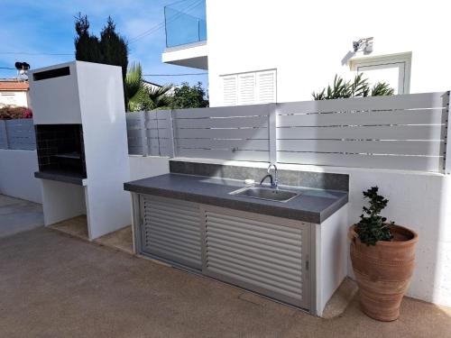 a sink on the side of a white fence at Geo Panoramic Villa +Pool +Game Room +Gym in Protaras