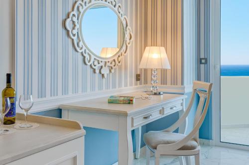 a room with a desk with a chair and a mirror at Rodos Palladium Leisure & Wellness in Faliraki