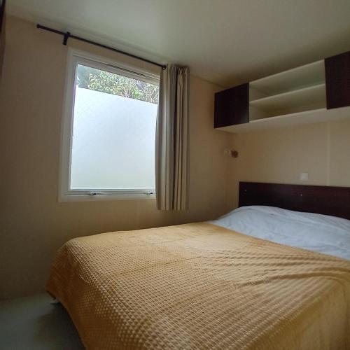 une chambre avec un lit et une fenêtre dans l'établissement Mobilhome 6 pers PLAGE À 500M, à Plage dʼArgelès