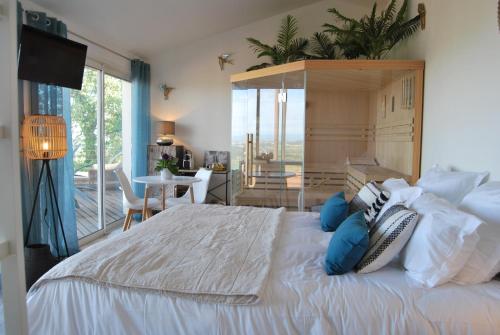 1 dormitorio con 1 cama blanca grande con almohadas azules en Les Hauts d'Avignon, en Rochefort-du-Gard