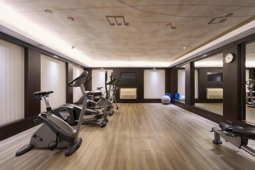 a gym with treadmills and exercise bikes in a room at Catalonia Rigoletto in Barcelona