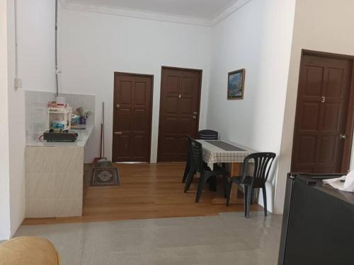 a kitchen and dining room with a table and chairs at Homestay Lembah Tambunan in Kampong Nail