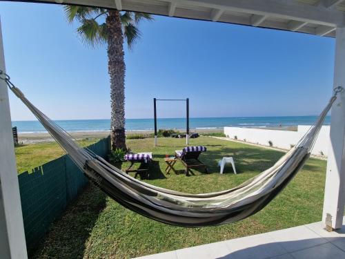 a hammock on the side of a beach at Ammos Beachfront Villa Paradise in Larnaka