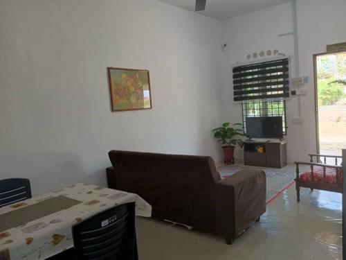 ein Wohnzimmer mit einem Sofa und einem TV in der Unterkunft Homestay Lembah Tambunan in Kampong Nail
