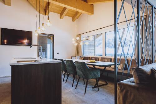 a kitchen and dining room with a table and chairs at GLEMM by AvenidA Superior Hotel & Residences in Saalbach Hinterglemm