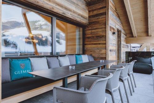 a dining room with a table and chairs at GLEMM by AvenidA Superior Hotel & Residences in Saalbach Hinterglemm