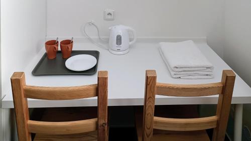 a white table with two chairs and a table with a napkin at Guest House Prague Airport in Prague