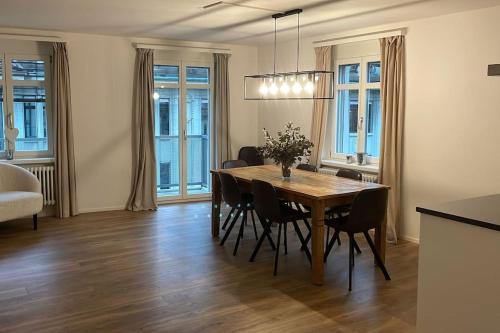 a dining room with a wooden table and chairs at Amazing two bedroom Penthouse in the city centre (Canal1) in Zurich