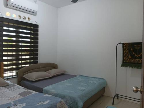 a bedroom with two beds and a window at Homestay Lembah Tambunan in Kampong Nail