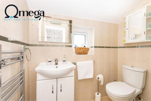 a bathroom with a white toilet and a sink at Double Room with a shared Kitchen and bathroom in a 5-Bedroom House at Hanwell in Hanwell