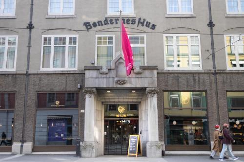 un edificio con una bandera rosa delante de él en Hotell Bondeheimen en Oslo