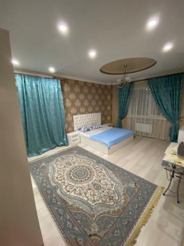 1 dormitorio con cama azul y alfombra en 2х комнатная квартира, en Shymkent