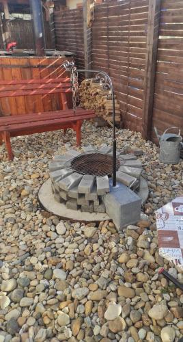 a bench and a fire pit in a gravel yard at Amur Vendégház in Gárdony