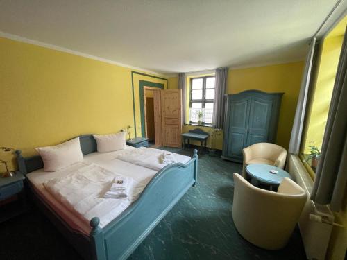 1 dormitorio con 1 cama y 1 silla en Warener Hof Apartments, en Waren