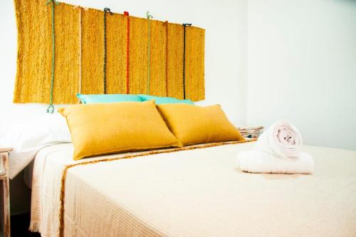 a bedroom with a bed with yellow and blue pillows at Famara Surf in Famara
