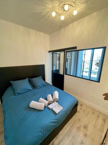 een slaapkamer met een bed met handdoeken erop bij Escale Confort in Montlhéry