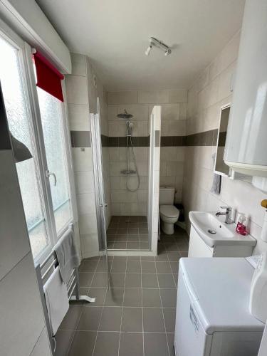 een badkamer met een douche, een toilet en een wastafel bij Escale Confort in Montlhéry
