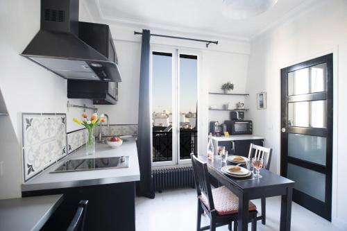 une cuisine avec une table et une salle à manger dans l'établissement GuestReady - 2 pièces lumineux vue sur Notre Dame, à Paris