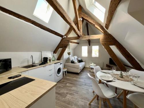 a kitchen and living room with a table and chairs at Le Cosy - Hyper Centre Ville in Sens