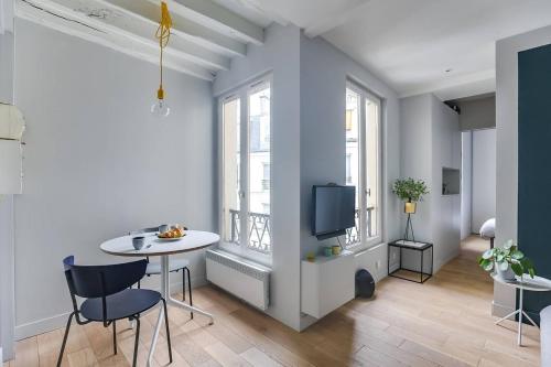 un salon avec une table et une télévision dans l'établissement GuestReady - Serene 1BR Apt in Folie-Méricourt, à Paris