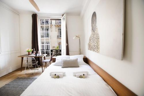 a bedroom with a bed with two pillows on it at GuestReady - Charming Studio 10 mins to Louvre in Paris