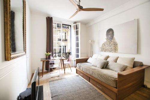 un salon avec un lit et une table dans l'établissement GuestReady - Charmant studio à 10 mins du Louvre, à Paris