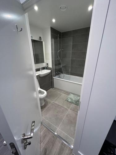 a bathroom with a shower and a toilet and a sink at Immaculate 2-Bed Apartment in Canning Town in London