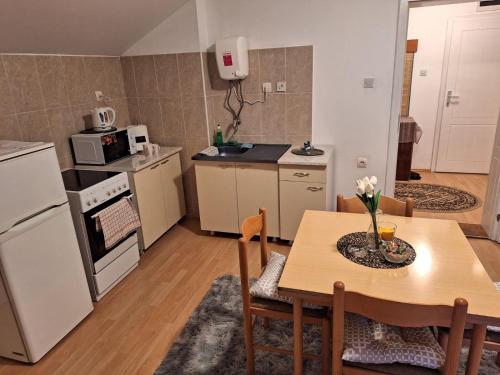 a kitchen with a wooden table and a kitchen with a table and chairs at APARTMAN ŽELJA in Sremska Mitrovica