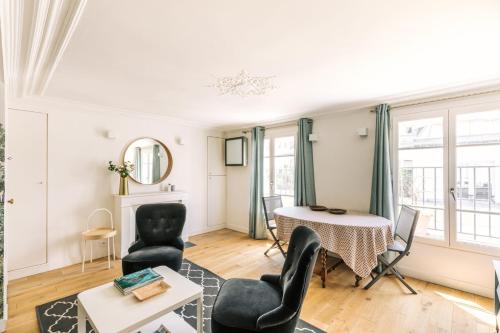 un salon avec une table et des chaises dans l'établissement GuestReady - Incroyable Apt Paris pour 2 dans 7arr, à Paris