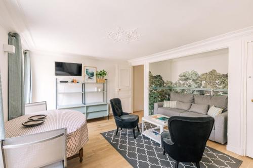 un salon avec un canapé, une table et des chaises dans l'établissement GuestReady - Incroyable Apt Paris pour 2 dans 7arr, à Paris